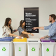 UK SME staff sort materials at labeled bins with 'Waste Reduction' text
